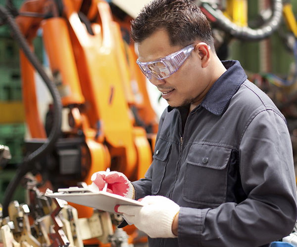 engenheiro industrial escrever no bloco de notas na fábrica